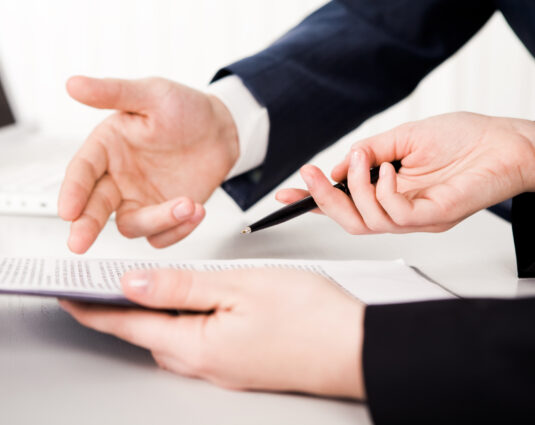 Portrait of executive employee looking at business partner while explaining her viewpoint during meeting